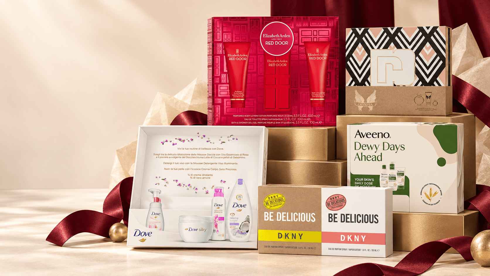 Premium beauty and fragrance gift sets arranged with burgundy ribbon